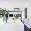 Charming White Details Dominate Impeccable Minimalist Home in Germany: Amazing White Kitchen Ideas With Awesome White Kitchen Island Design And Microwave Oven Wall As Well As Ceiling Extractor Hoods Above Electric And Gas Stove In Kitchen Island