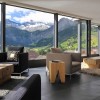 Dazzling Hotel Interior In Switzerland Reveals Spectacular Mountain Views: Glass Wall Design In The Modern Home Decorating Ideas Living Room With Beige And Black Sofa With Wooden Coffee Table And Gray Rug With White Ceiling Paint