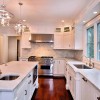 Captivating Kitchen Island with Impressive Seating Unit: Stupendous White Kitchen Design Embellished With Wonderful White Kitchen Island As Well As White Brick Kitchen Backsplash With Wooden Flooring And Two Chandelier