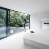 Charming White Details Dominate Impeccable Minimalist Home In Germany: Stunning Bedroom Interior Design With Wonderful White Bedding And Floor Mirror As Well As Glass Railing With Sliding Glass Doors Complement The Bedroom Interior With White Walls