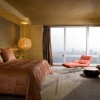 Wonderful Bedroom Designs With Classy And Luxurious Style: Luxury One Bedroom Apartments Equipped With A Splendid Pendant Lamp And Awesome Brown Bedding With Vibrant Orange Lounge Chair As Well As Wonderful Modern Gray Curtains