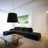 White and Black Details For Amazing Home Interior Design: Modern Sofa Adorn Amazing Living Room With Black Color With Black Pendant Lamp Above Modern Wood Coffee Table And LED Track Lights And Amazing Artwork On The White Walls