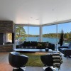 Inspiring Modern Home Interior Design Accentuating Simplicity and Functionality: Captivating Lake Views Seen From Extended Floor To Ceiling Windows Of Contemporary House Decorating Design With A Rustic Fireplace And Modern Furniture Set In Black Shade
