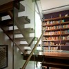 Enticing Staircase Landing Designs Applying Creative Ideas: Wood Floor Laminate And Glass Staircase Railing With Attractive Bookshelves For Modern Home Design