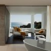 Breathtaking Contemporary Beach House with Perfect Architecture: Contemporary Bathroom Interior Completed With One Chair And Modern White Sofa With White Table As Well As Contemporary White Bathtub