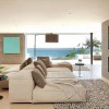 Breathtaking Contemporary Beach House with Perfect Architecture: Family Room Decor Embellished With Wall Mounted TV Above The Fireplace With Knitted Rug And Brown Pillows On Comfy Sofa Near Black Round Table