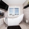 Creative Ideas Modifying Contemporary Bathroom Designs: Modern Small Bathroom Design Equipped With Electric Fireplace And Black Shag Bath Mats With Stunning White Bathtub And Flat Screen TV On The Wall