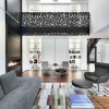 Bewitching Iron Lace Mansion In Canada Showcases Black-Dotted Staircase: Spectacular Living Room Interior Equipped With Wonderful Area Rugs And Swivel Chair With Footstool Plus Modern Sectional Sofa